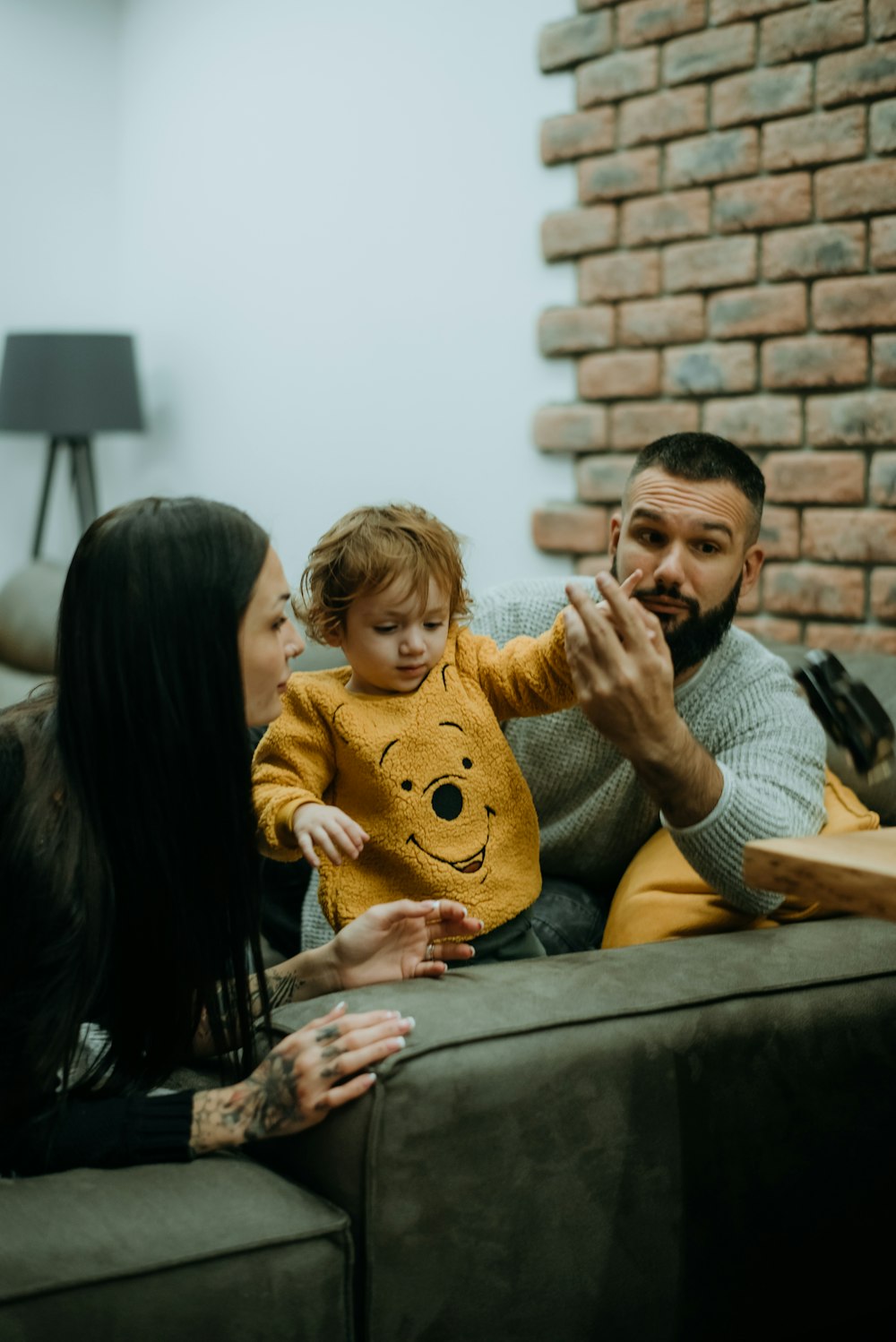 a man, woman and child sitting on a couch