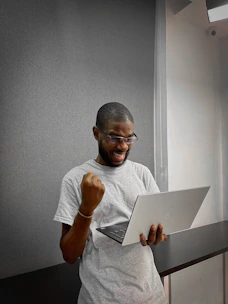 A person happily checking their energy bill on a laptop at home.