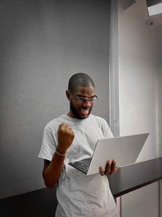 A person happily reviewing their digital resume on a laptop with career milestones displayed.