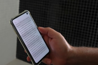 a person holding a smart phone with a book on the screen