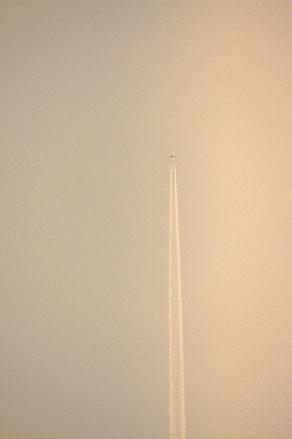 a plane flying in the sky with a trail of smoke behind it