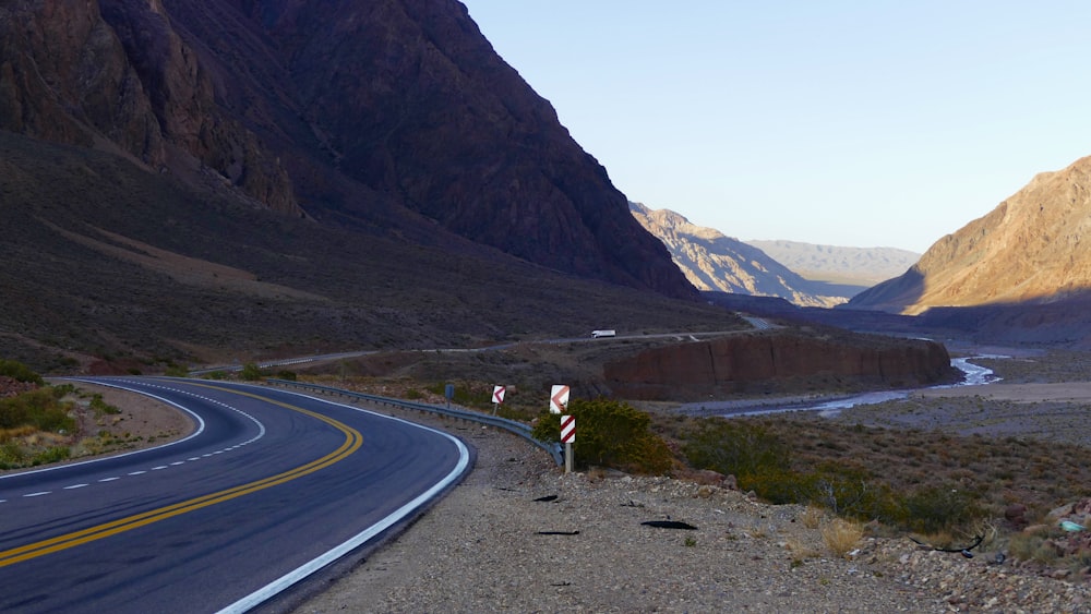 a road in the middle of a desert with mountains in the background