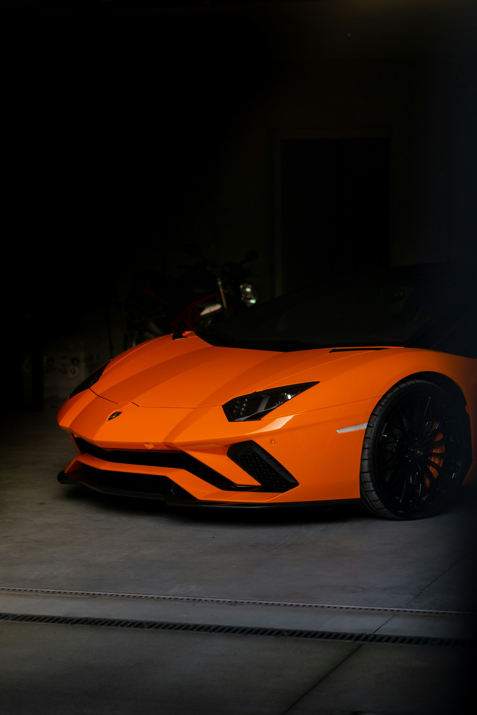 an orange sports car parked in a garage