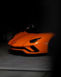 an orange sports car parked in a garage