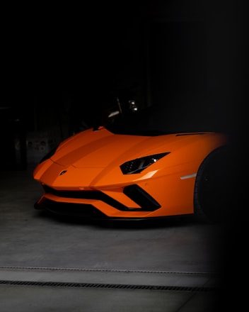 an orange sports car parked in a garage