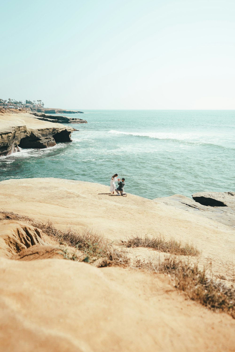 a person sitting on a rock near the ocean