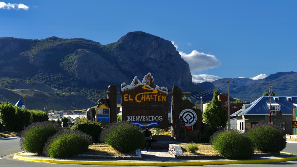 a sign for a town with mountains in the background