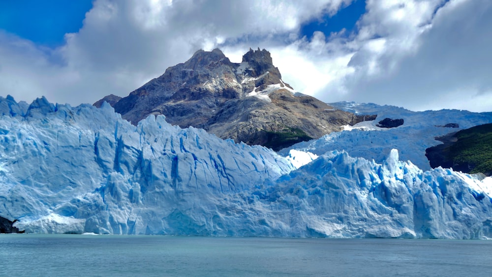 a large glacier with a mountain in the background