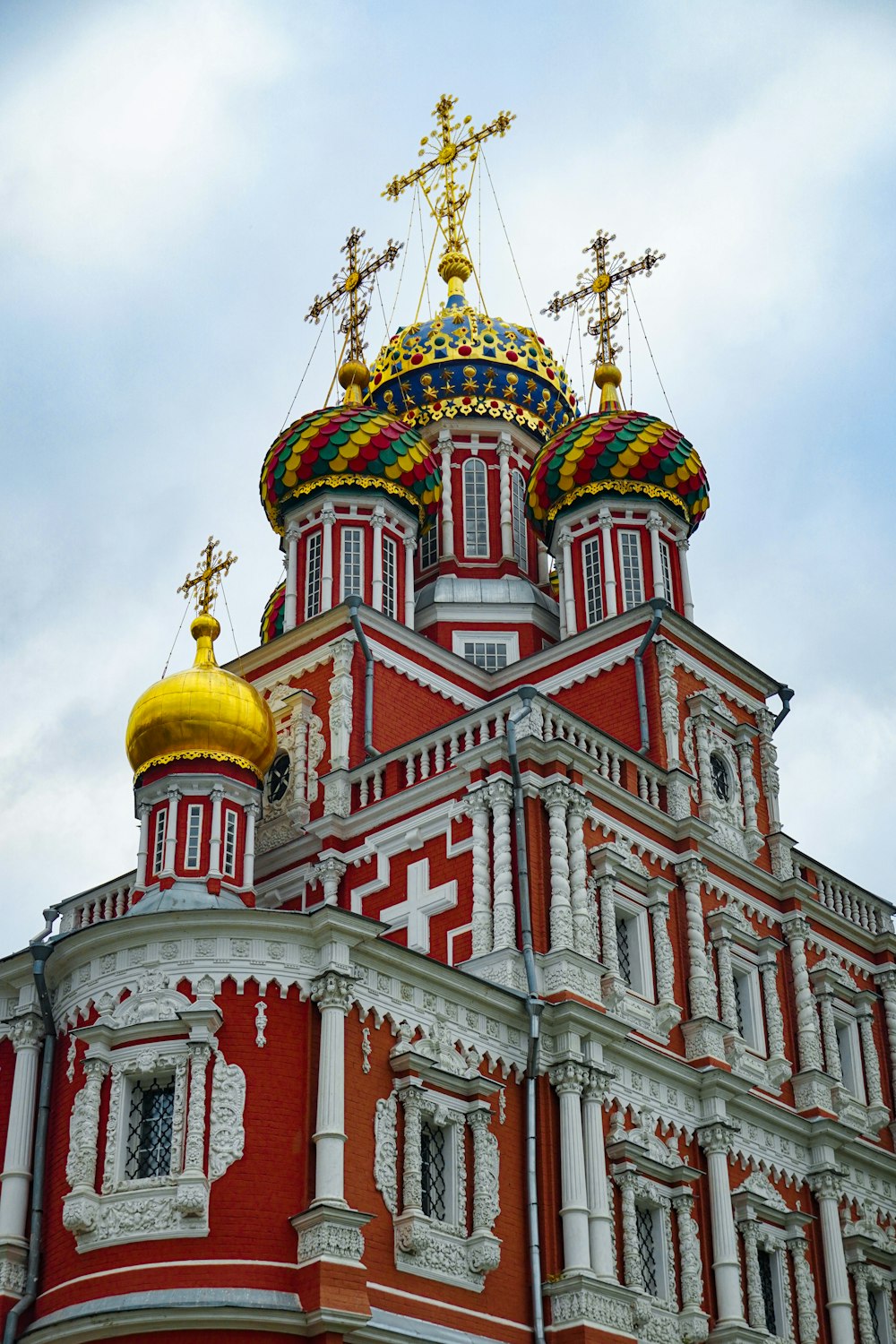 a large red and white building with a gold cross on top