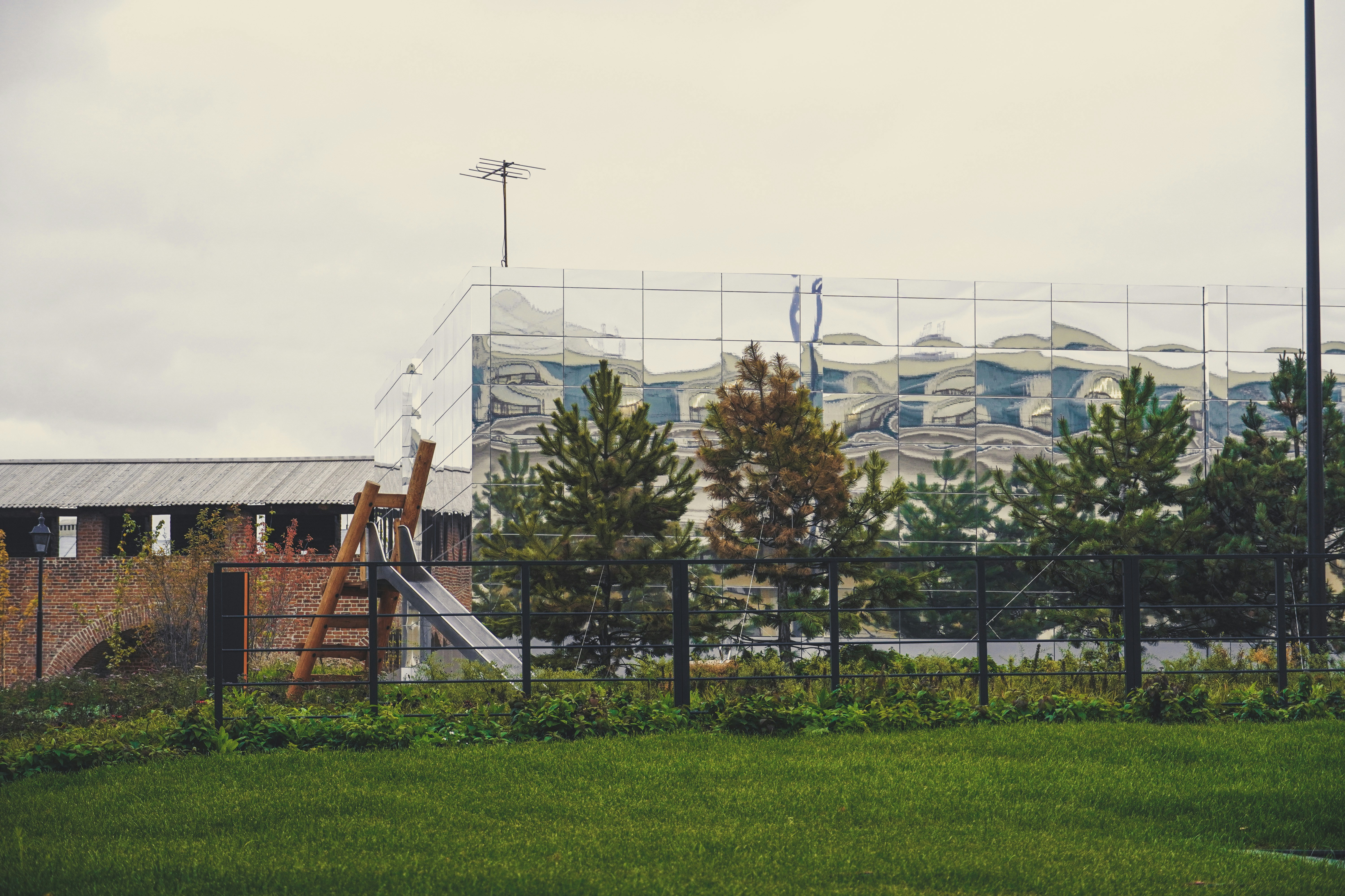 a building behind a fence with trees in front of it