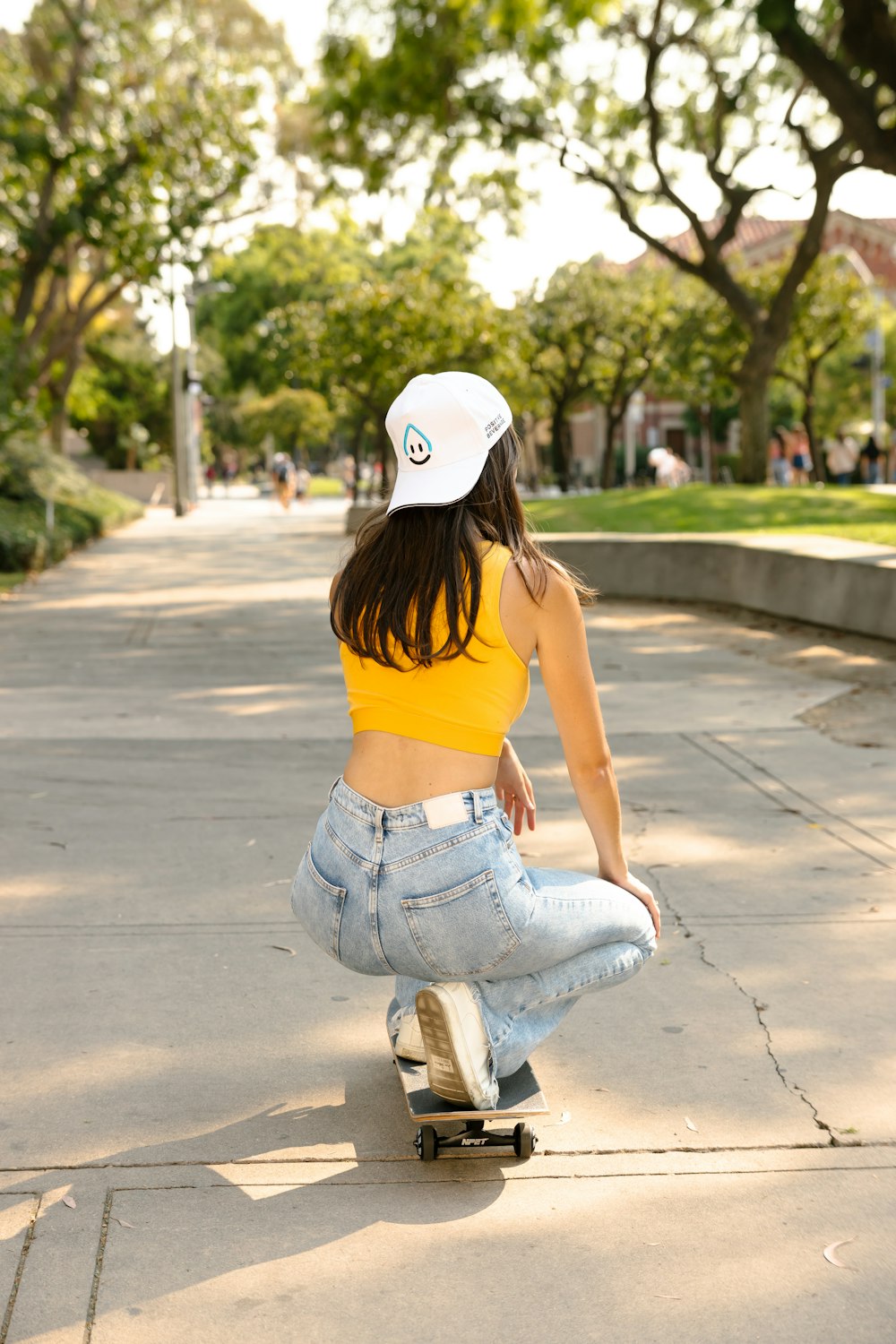 Una mujer montando una patineta por una acera