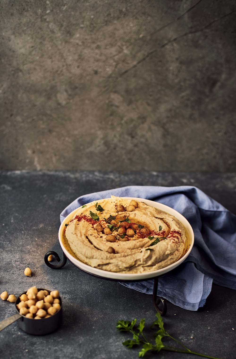 eine Schüssel Hummus mit Kichererbsen an der Seite