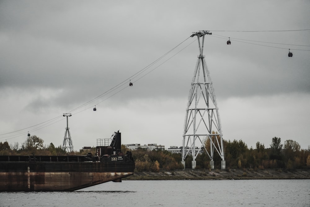 a large boat traveling down a river next to a power line