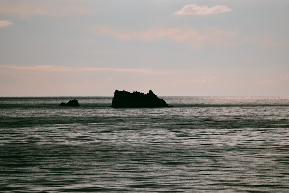 a large rock in the middle of a body of water