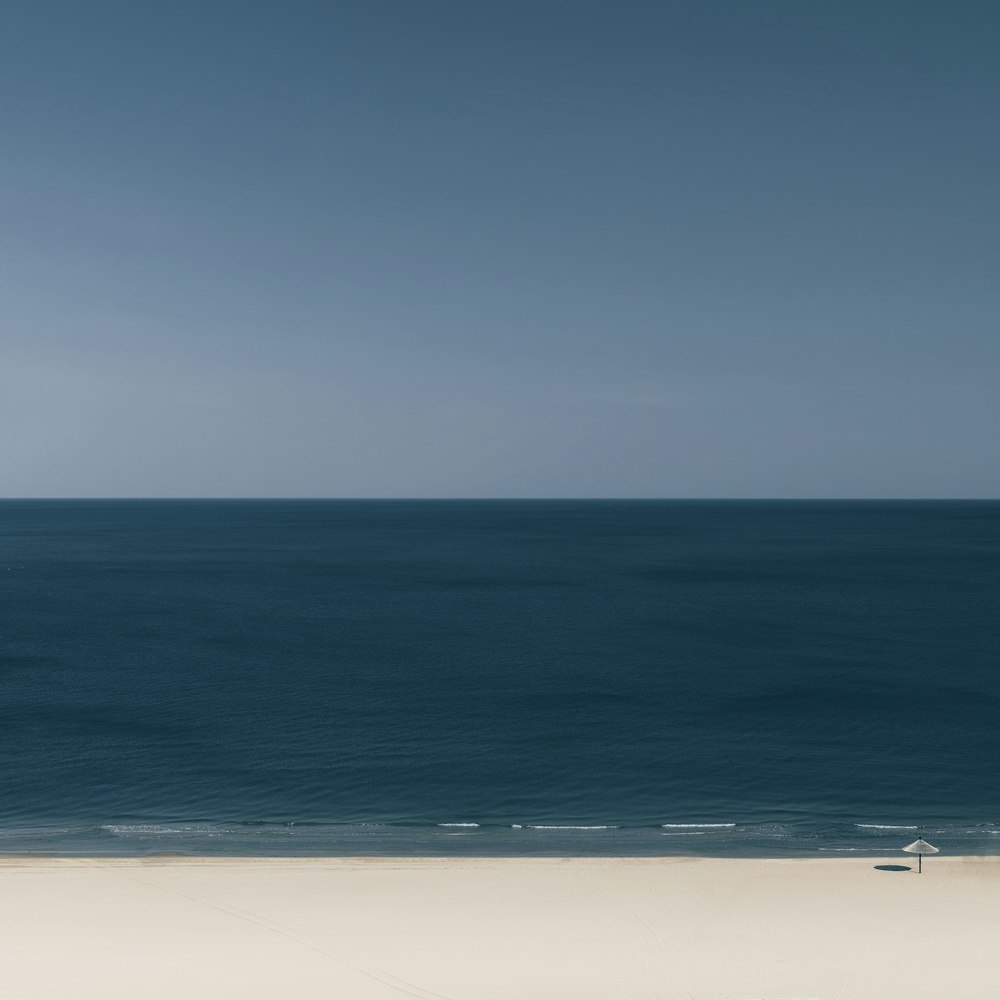 Una persona che cammina su una spiaggia vicino all'oceano