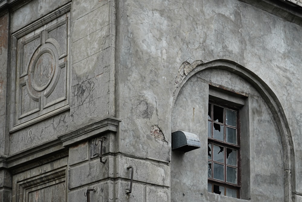 an old building with a broken window and a clock