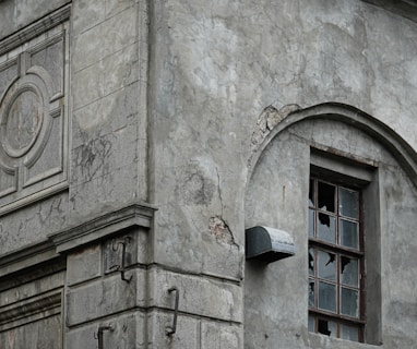 an old building with a broken window and a clock