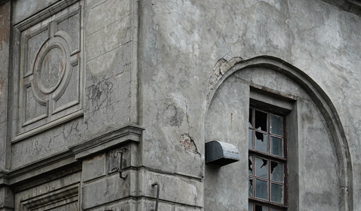 an old building with a broken window and a clock