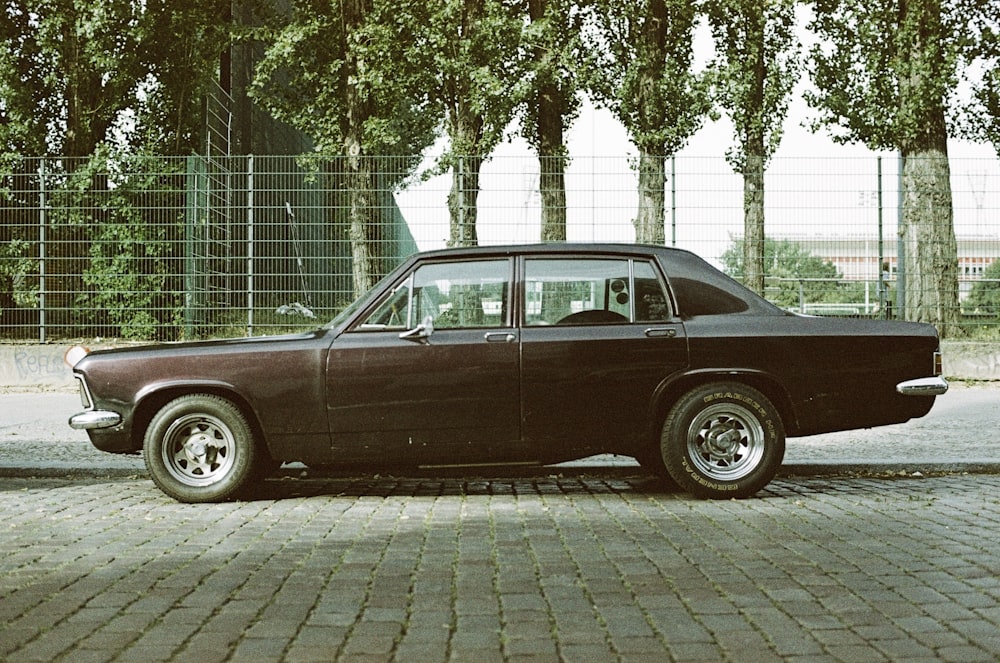 a black car parked on a brick road