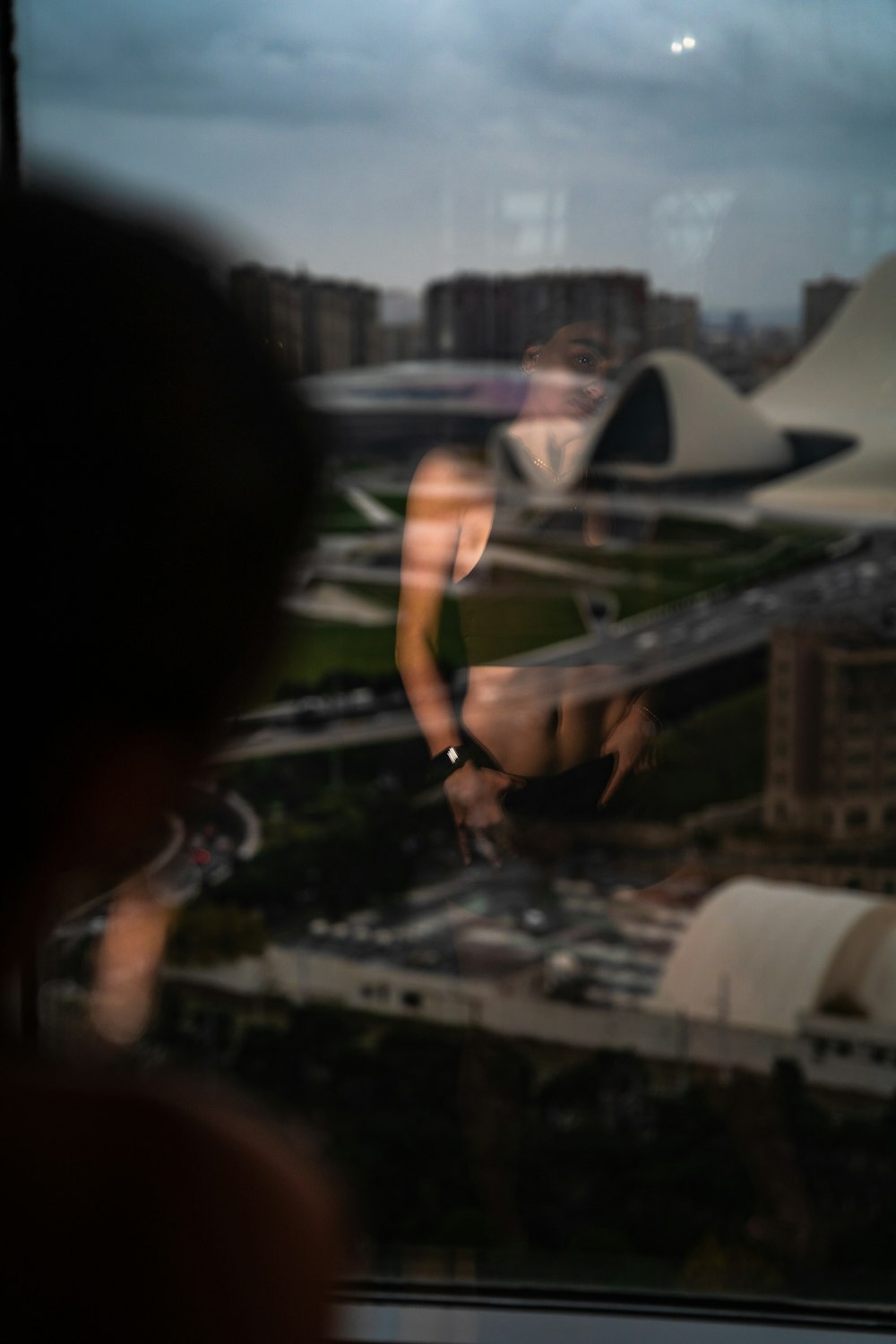 a person looking out a window at a city