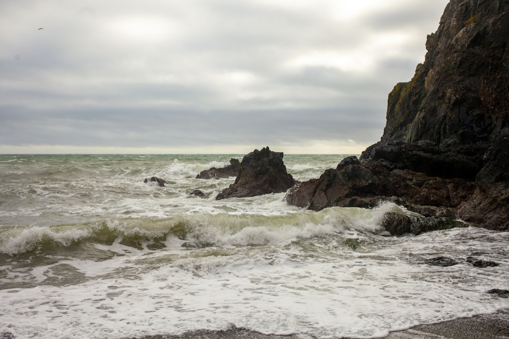 a rocky beach with waves crashing against the rocks