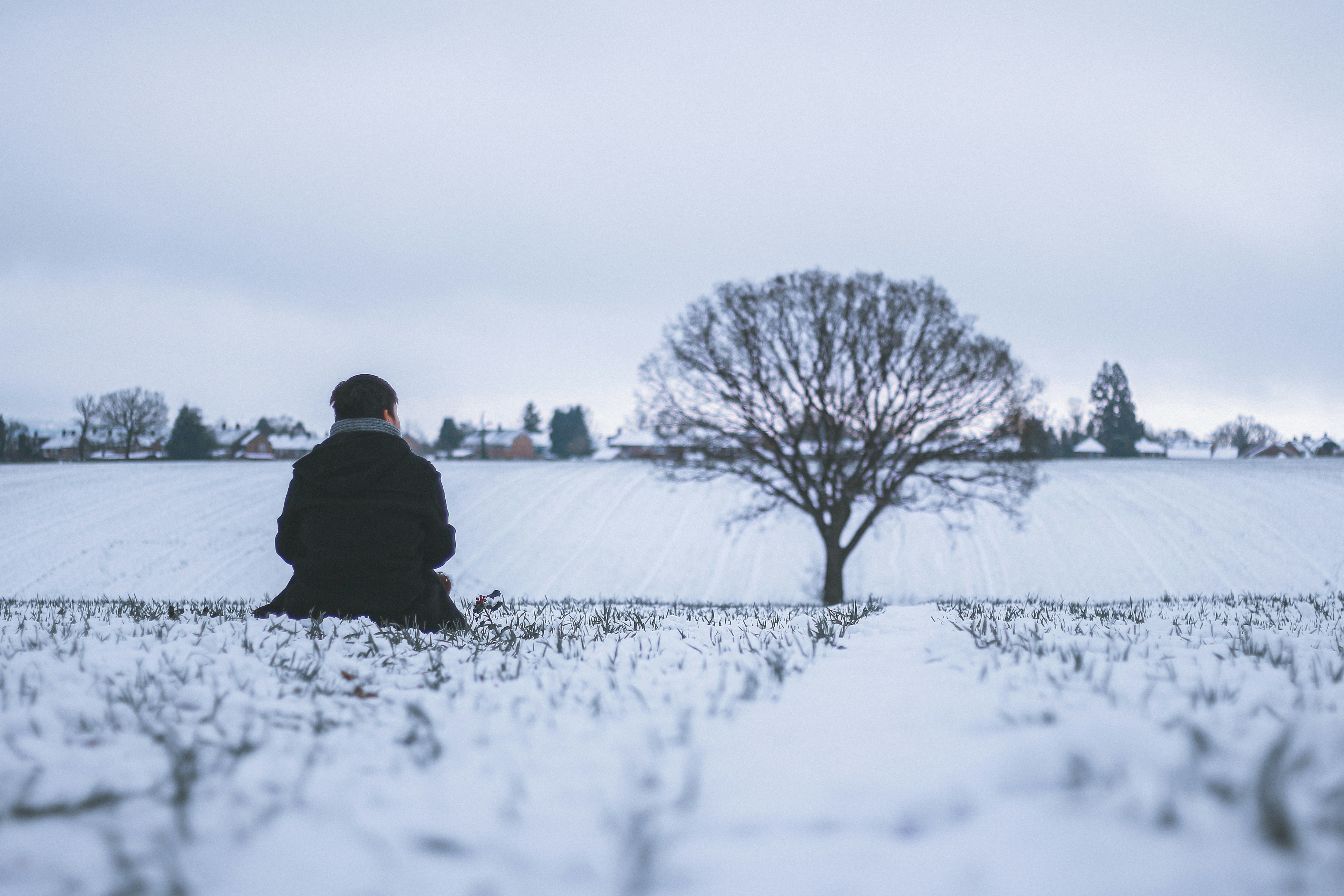 a person sitting on top of a snow covered field