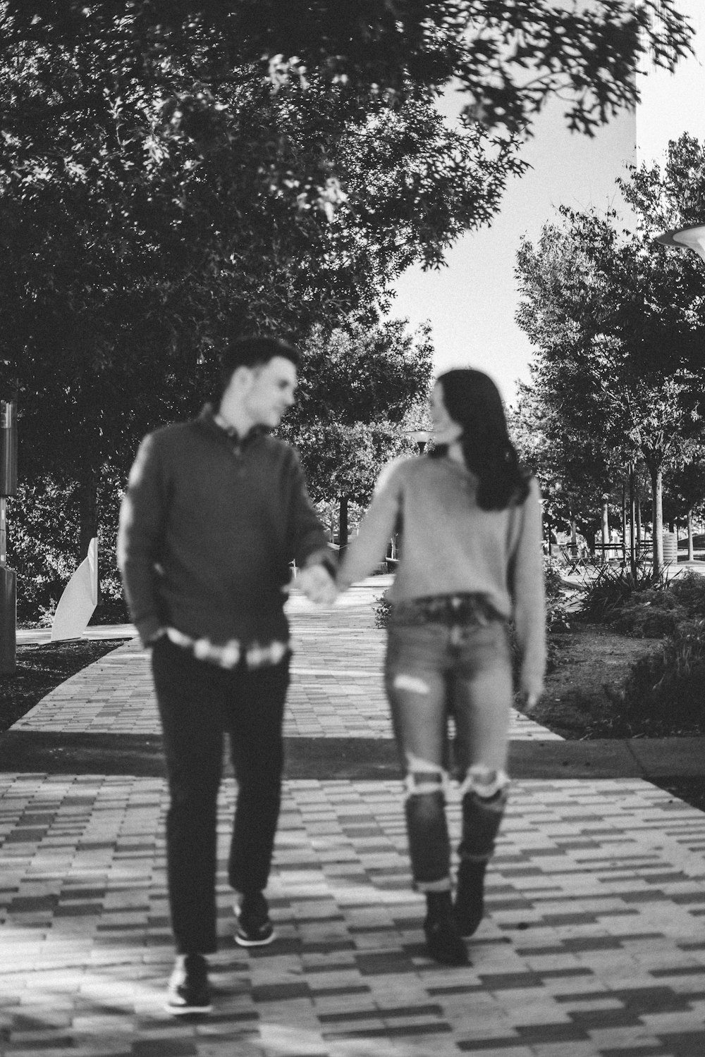 a man and a woman walking down a sidewalk holding hands