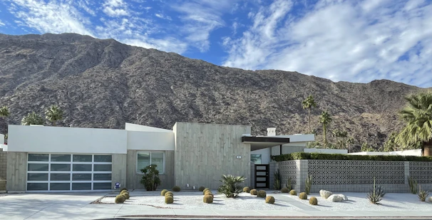 A newly completed modern residential home with clean lines and natural stone accents under a bright New Mexico sky.