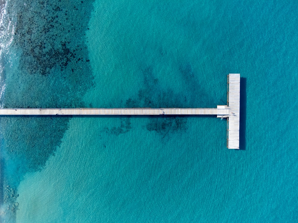 an aerial view of a pier in the middle of the ocean