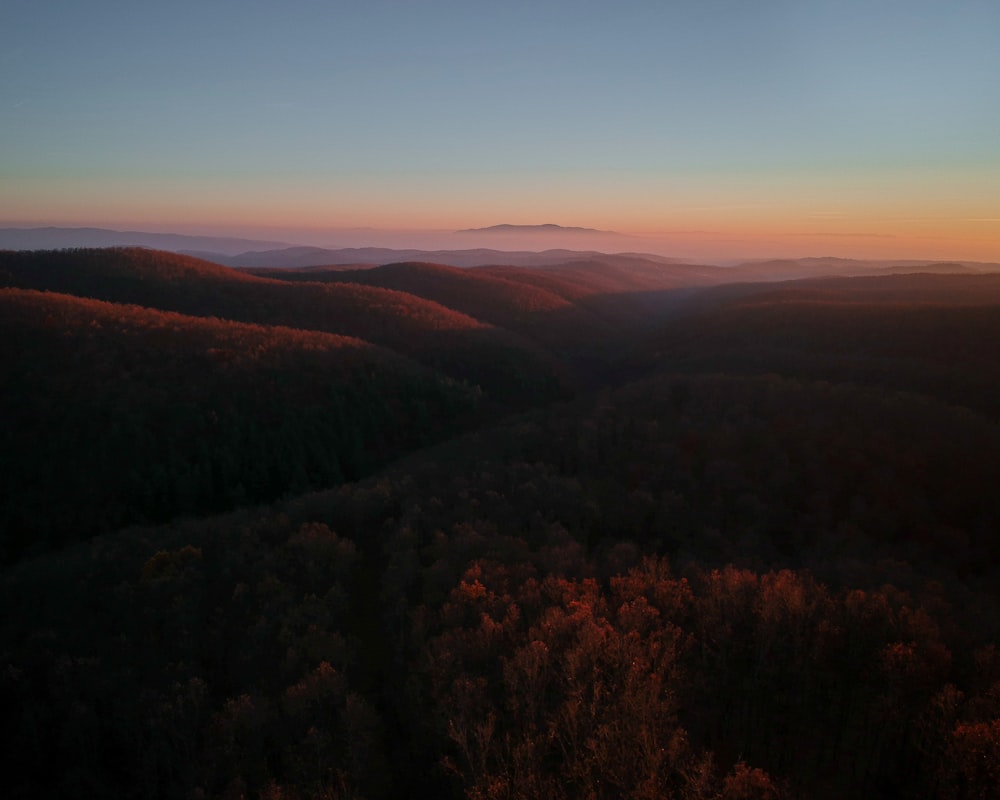 the sun is setting over the mountains in the distance