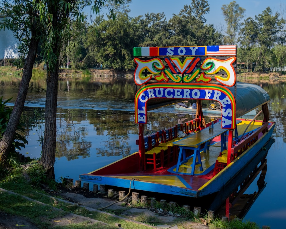 a colorful boat floating on top of a body of water