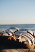 A pair of elegant sandals on a sandy beach.
