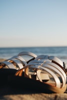 A pair of elegant summer sandals on a sandy beach.