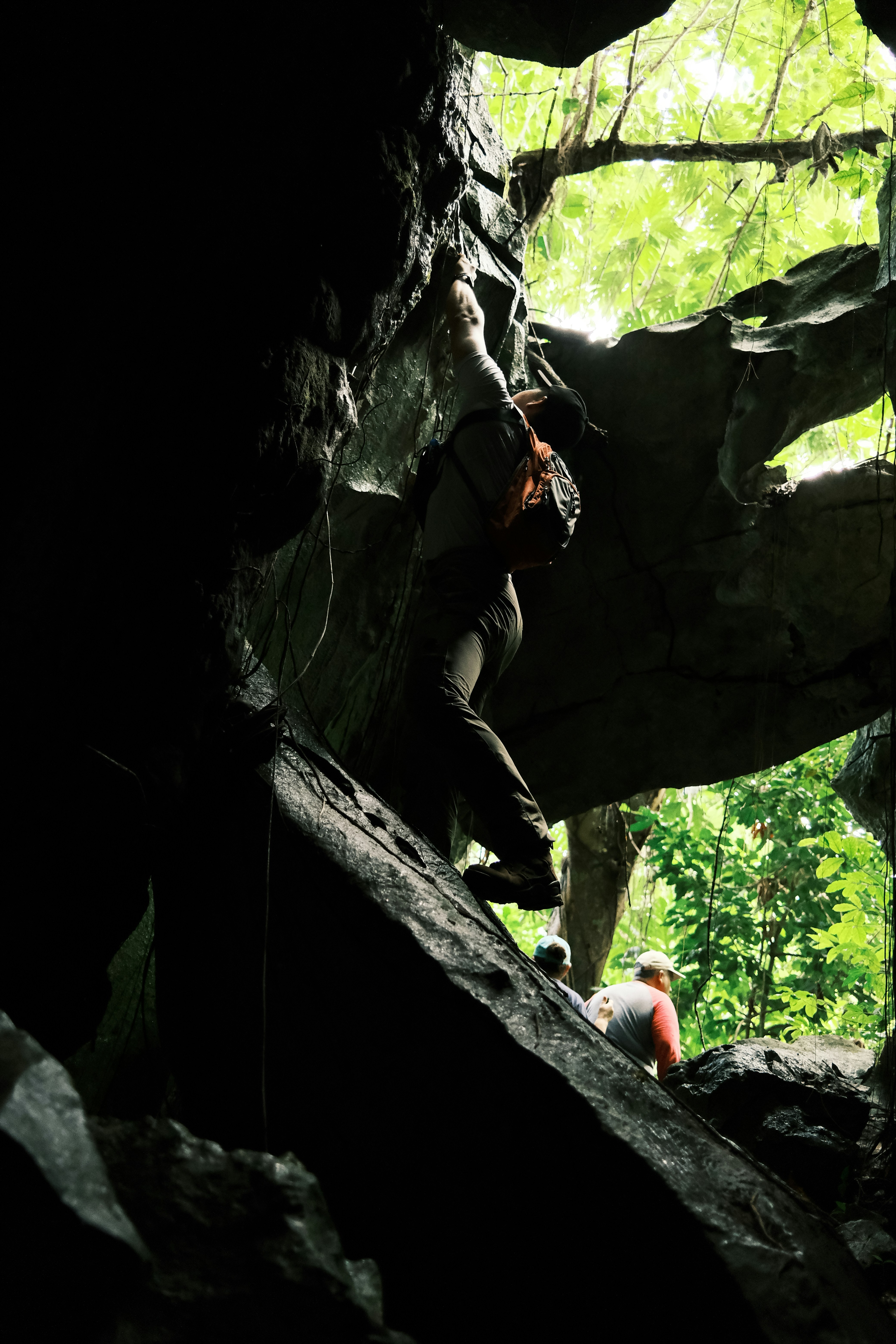 a man climbing up the side of a large rock