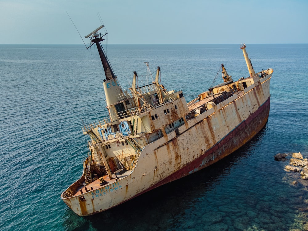 an old rusted ship in the middle of the ocean