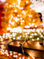 Close-up of twinkling Christmas lights wrapped around a porch railing with a snowy backdrop.