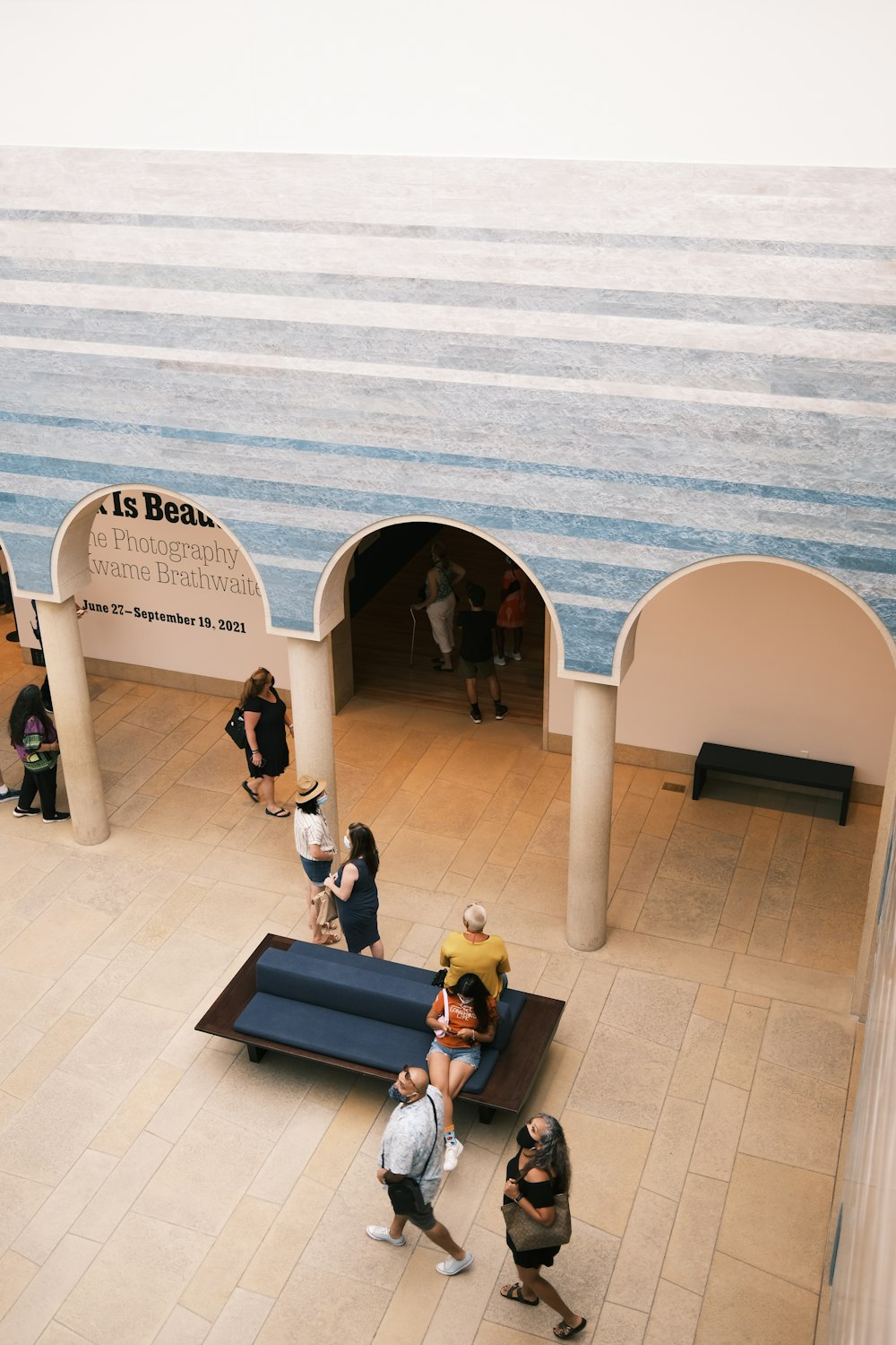 a group of people standing around a blue bench