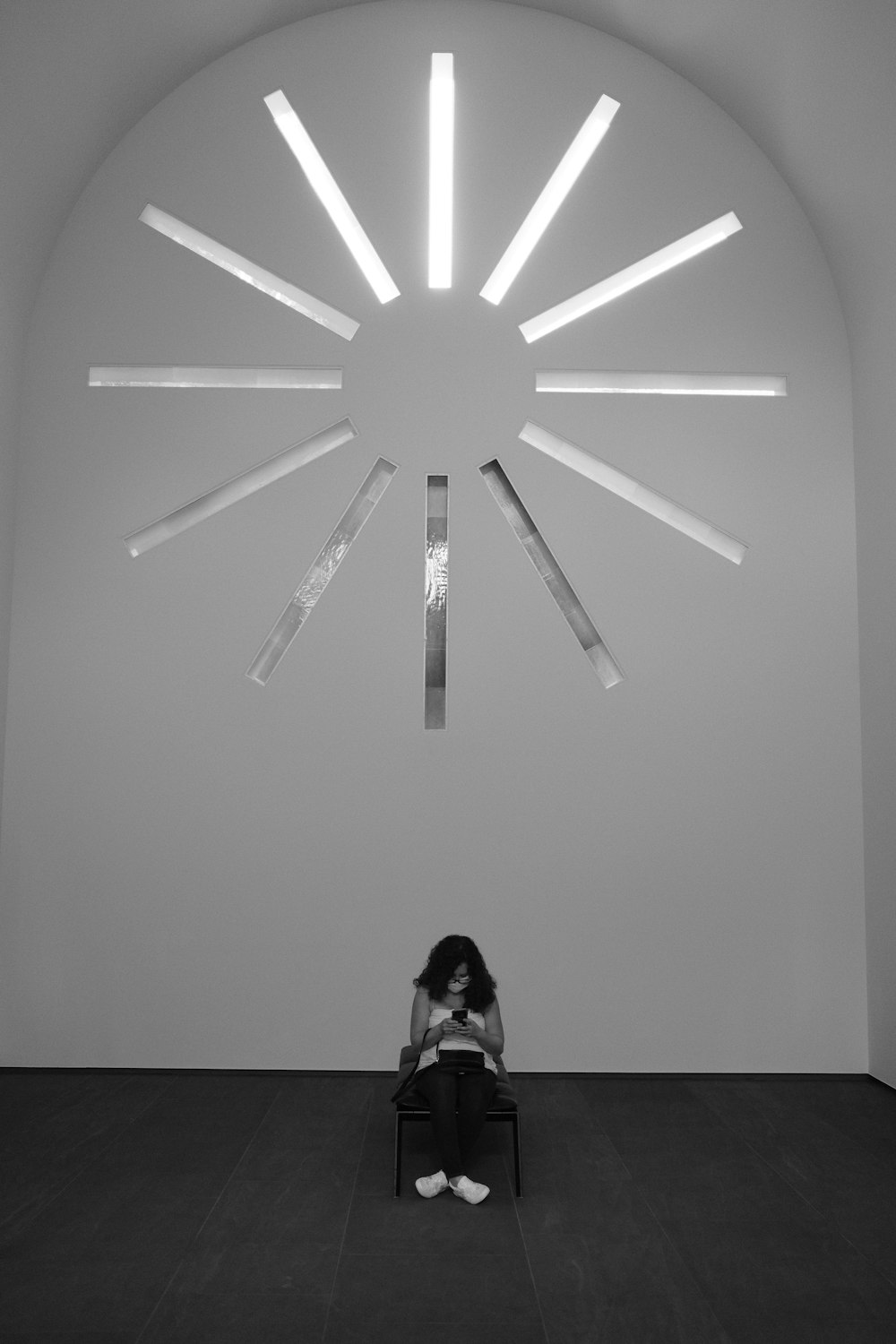 a woman sitting on a chair in front of a clock