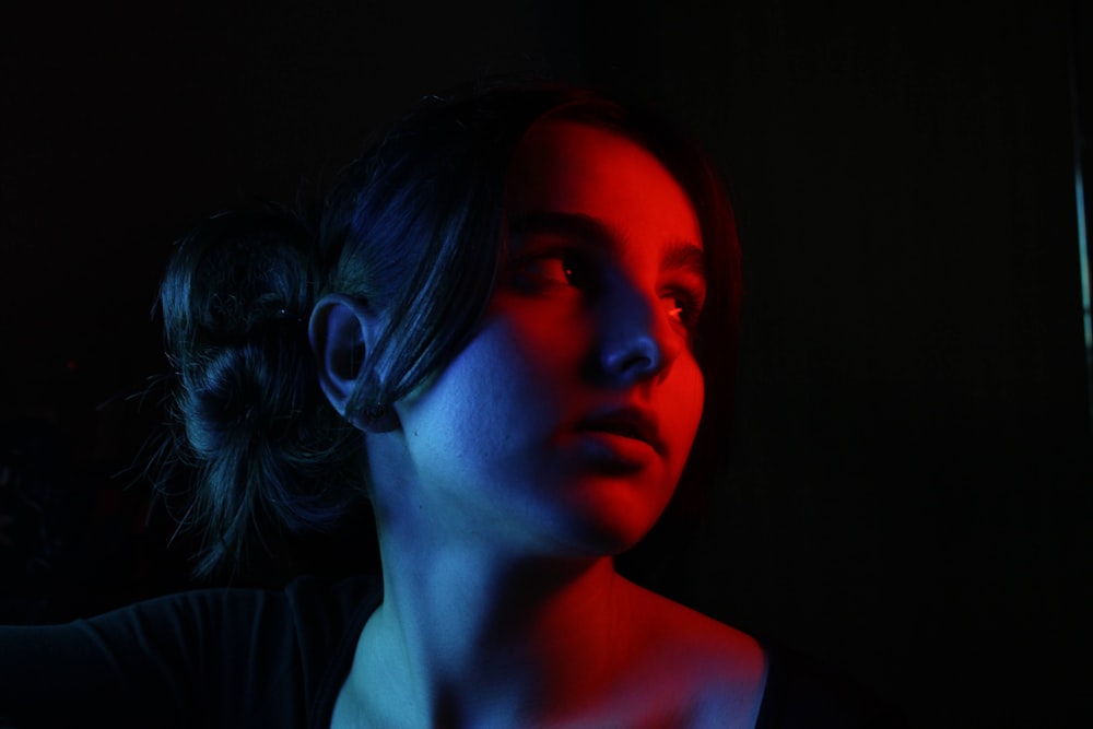 a woman in a dark room with a red light