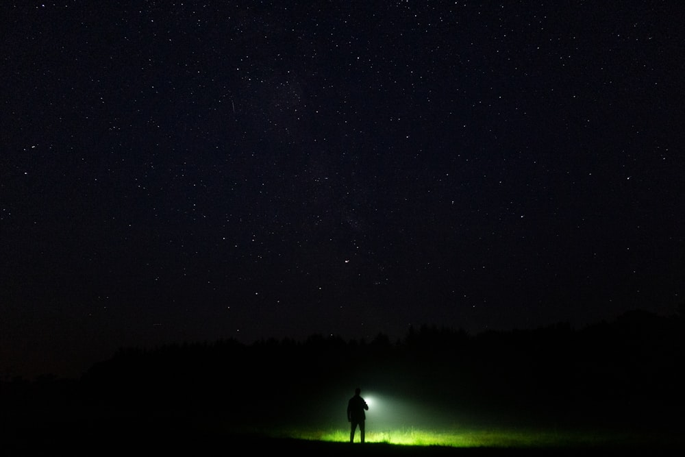 a person standing in a field at night