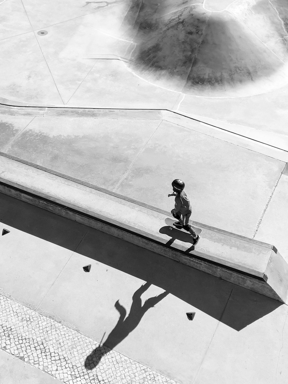 Un hombre montando una patineta por el costado de una rampa