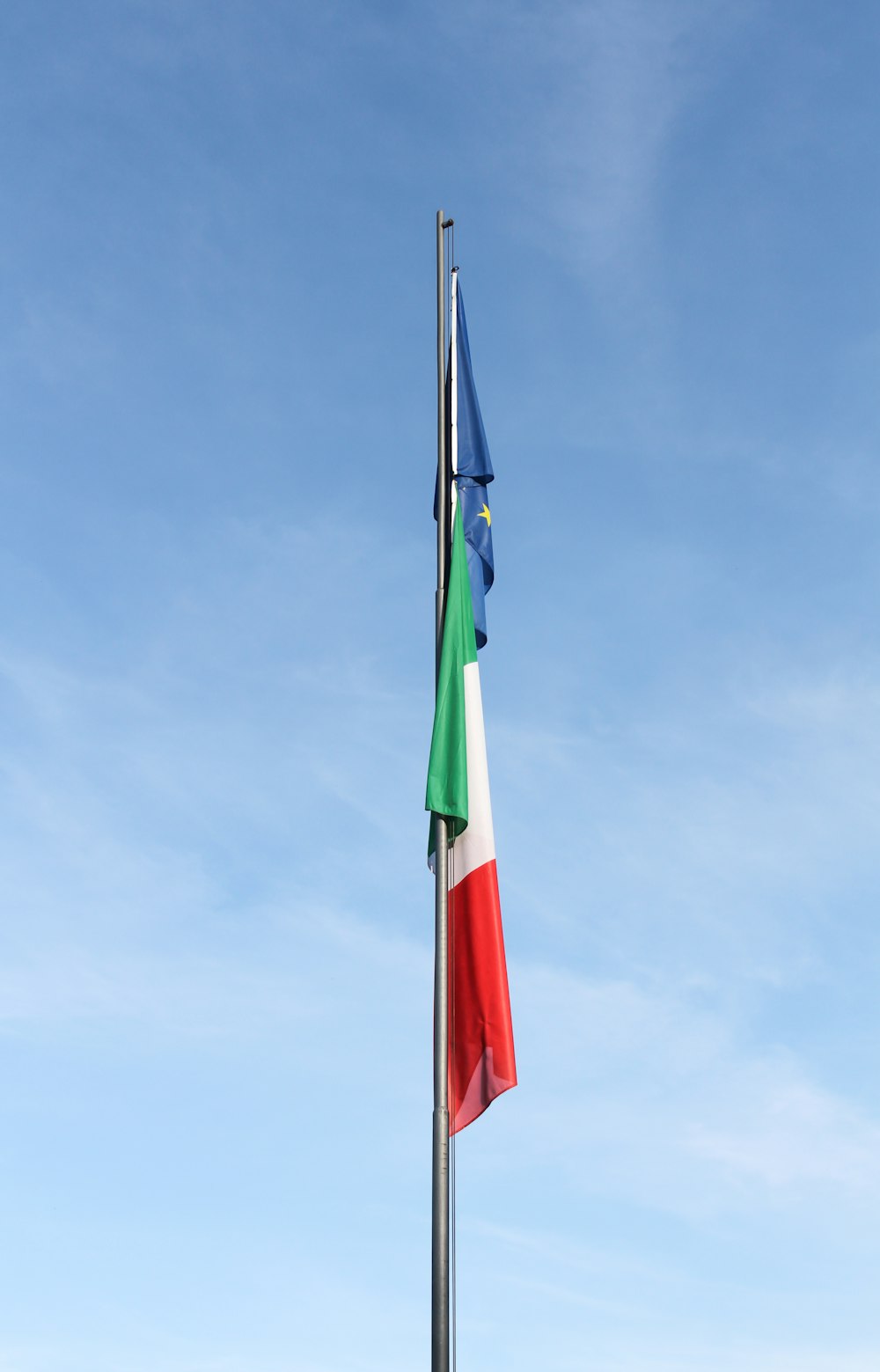 a flag pole with two flags on top of it