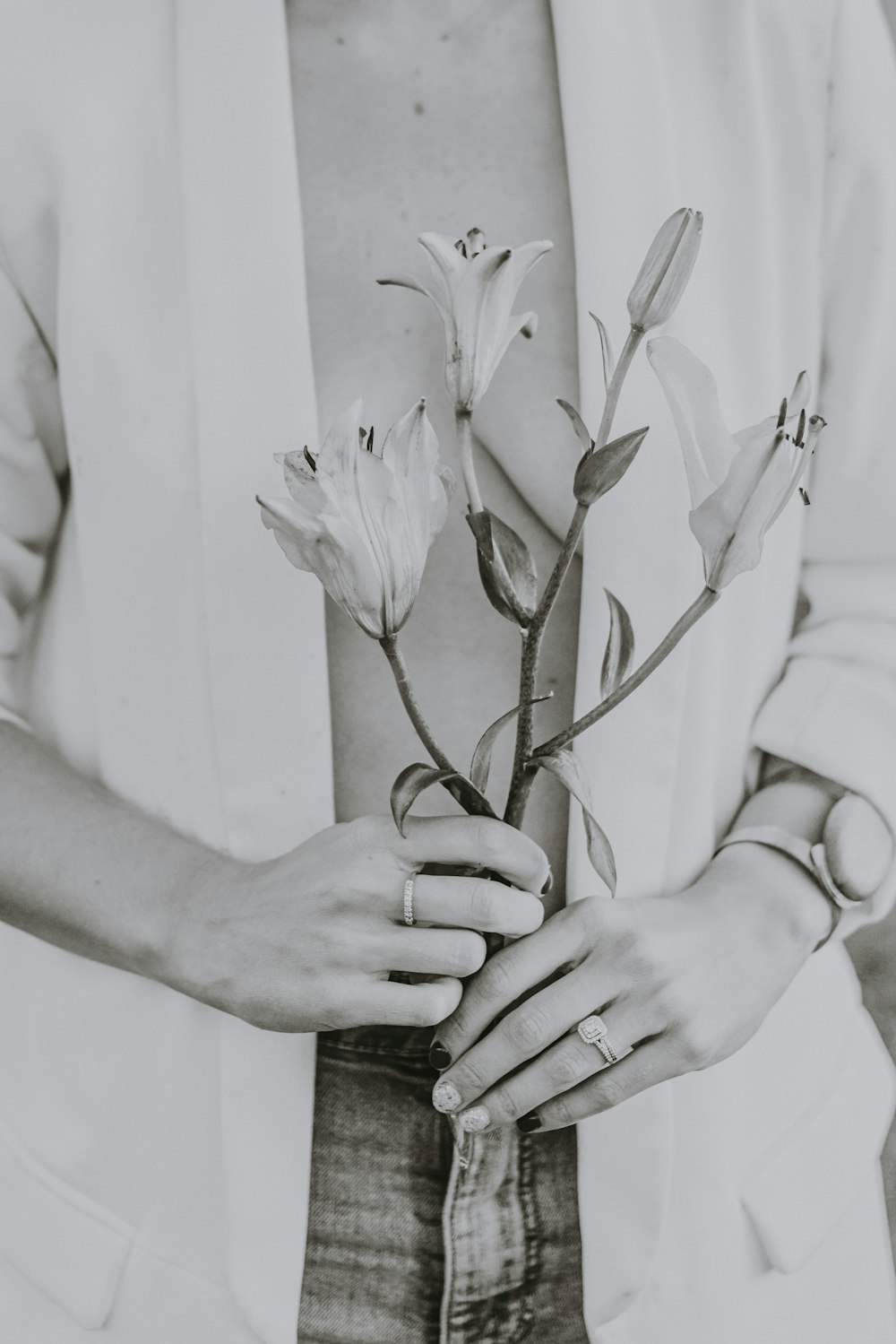 a black and white photo of a person holding a flower
