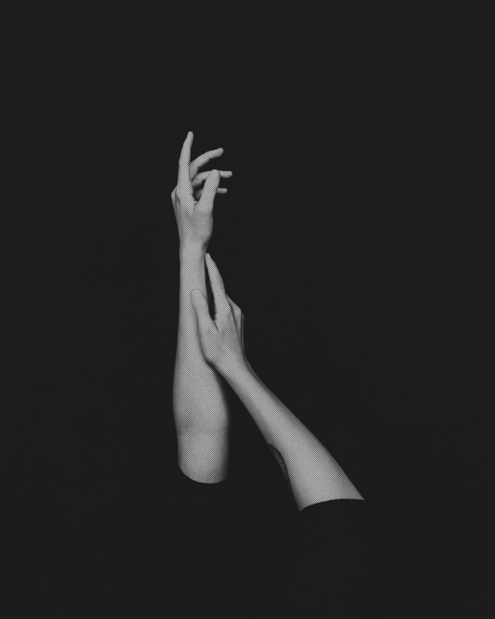 a black and white photo of two hands reaching up