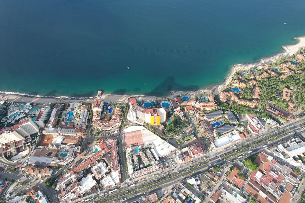 an aerial view of a city next to a body of water