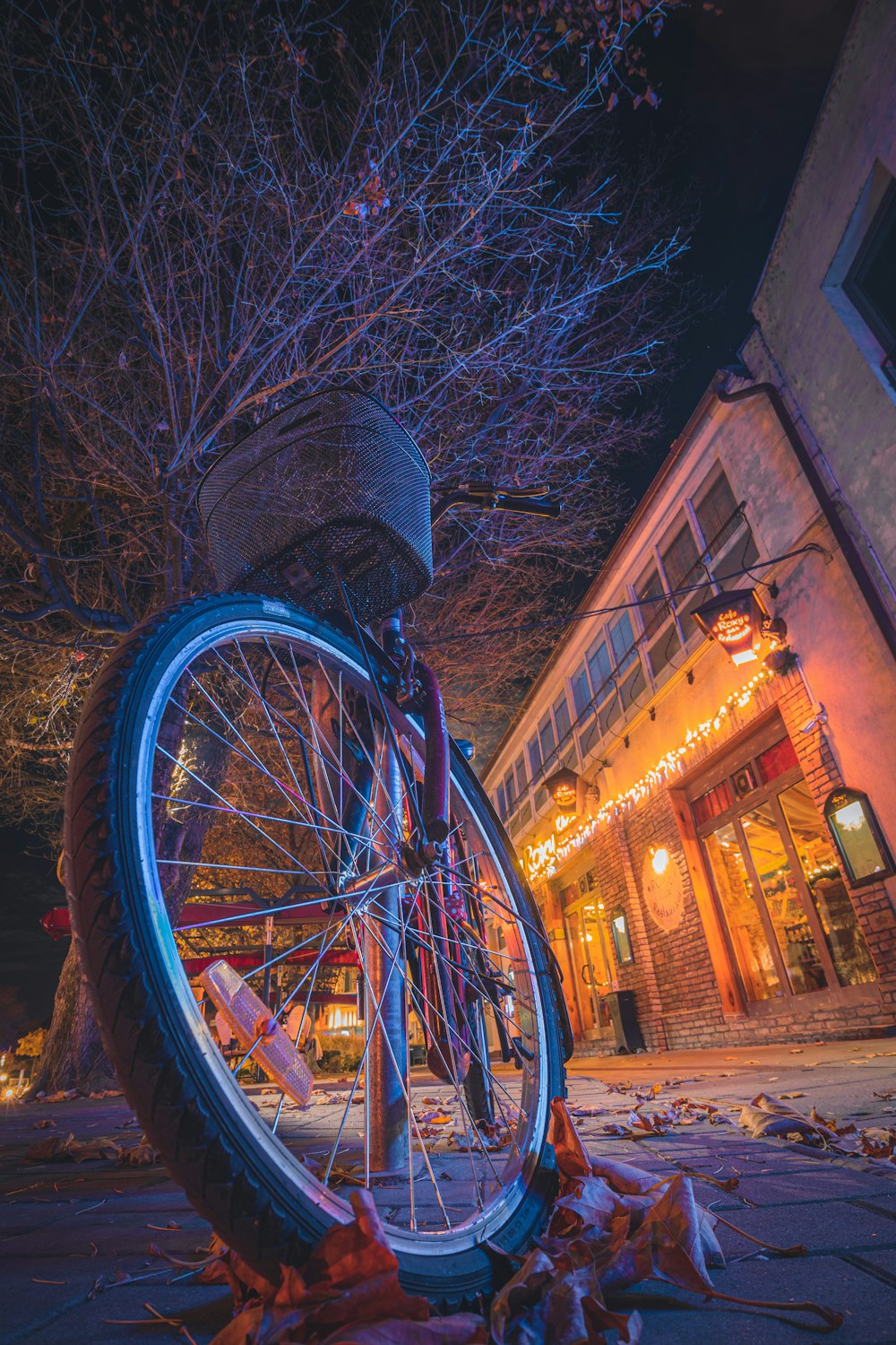 a bicycle parked on the side of a street next to a tree