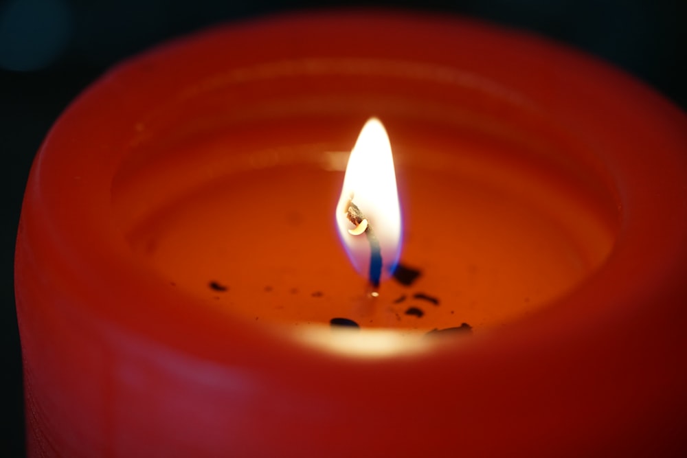 a red candle with a single candle stick sticking out of it