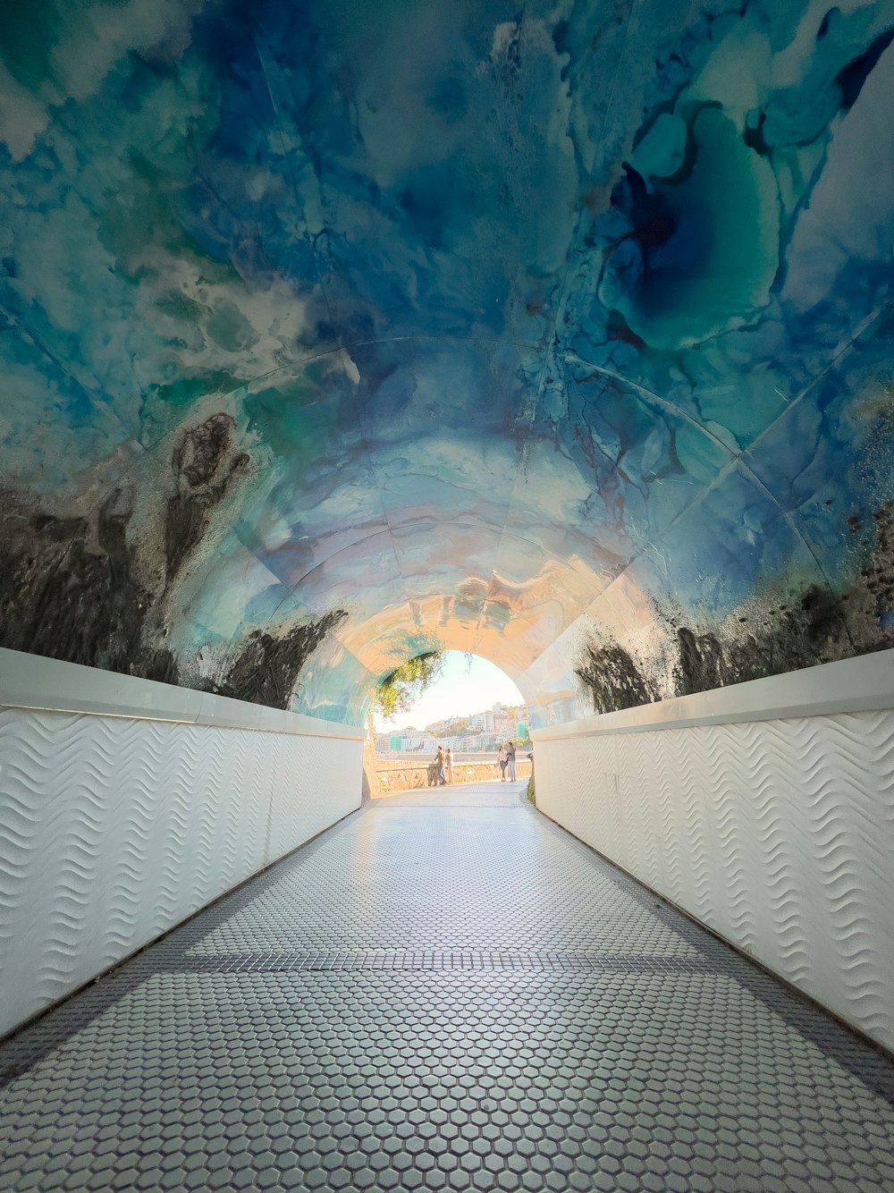a walkway leading to a blue and white painted ceiling