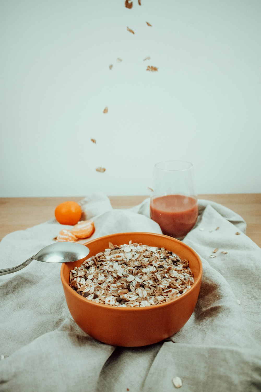 a bowl of oatmeal next to a glass of orange juice