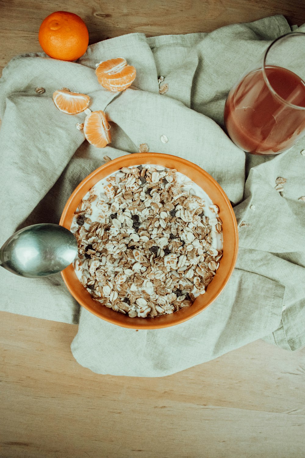 a bowl of oatmeal next to a glass of orange juice